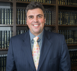Richard A. Klass, Esq., Principal, wearing colorful tie and dark blue suit coat.