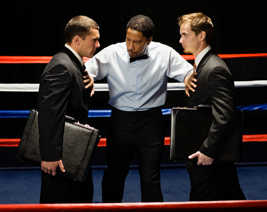 Referee separating two business men, illustrating article by Richard Klass Esq. about an arbitration clause in a contract