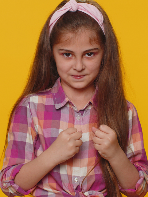 Aggressive preteen child girl kid making fight threat at camera
